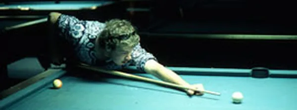 A man lining up a shot on one of Cue's regulation pool tables